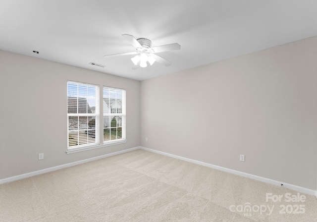 spare room with baseboards, visible vents, and light carpet