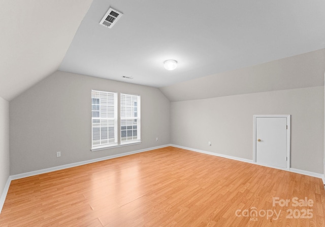 bonus room with baseboards, visible vents, and light wood finished floors