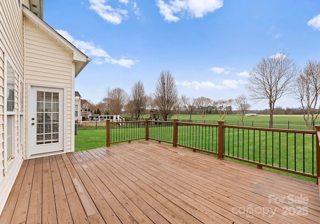 wooden deck featuring a lawn and fence