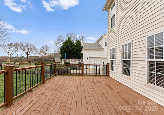 wooden terrace with a yard and fence