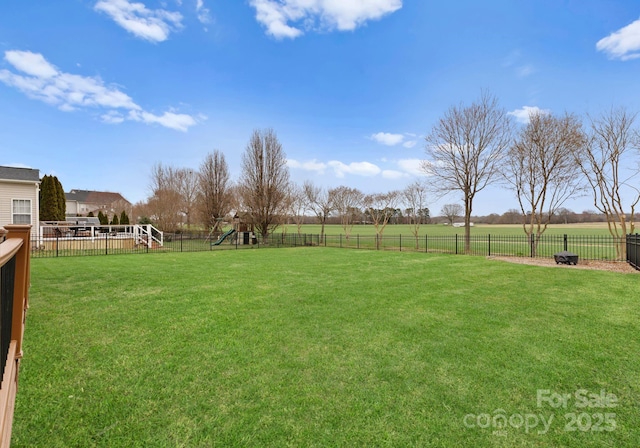 view of yard featuring a fenced backyard and a playground