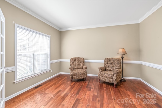 living area featuring visible vents, baseboards, and wood finished floors