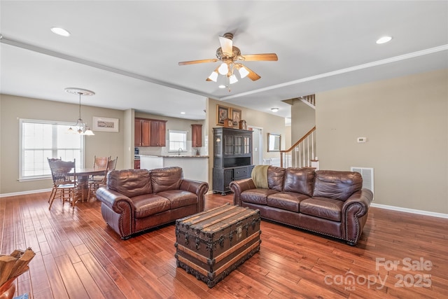 living area featuring stairway, baseboards, and hardwood / wood-style floors