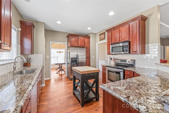 kitchen with a sink, plenty of natural light, appliances with stainless steel finishes, and light wood-style flooring