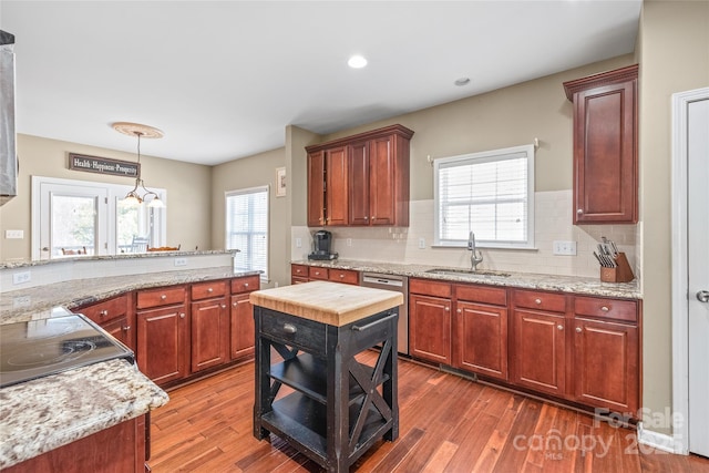 kitchen with dishwasher, hanging light fixtures, decorative backsplash, dark wood-style floors, and a sink