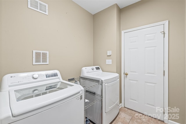 laundry area with light tile patterned floors, laundry area, independent washer and dryer, and visible vents