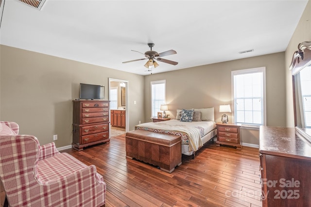 bedroom with dark wood-type flooring, baseboards, visible vents, and ceiling fan