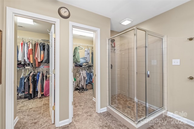 bathroom featuring a stall shower and baseboards