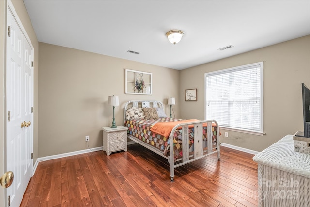 bedroom featuring visible vents, baseboards, and wood-type flooring