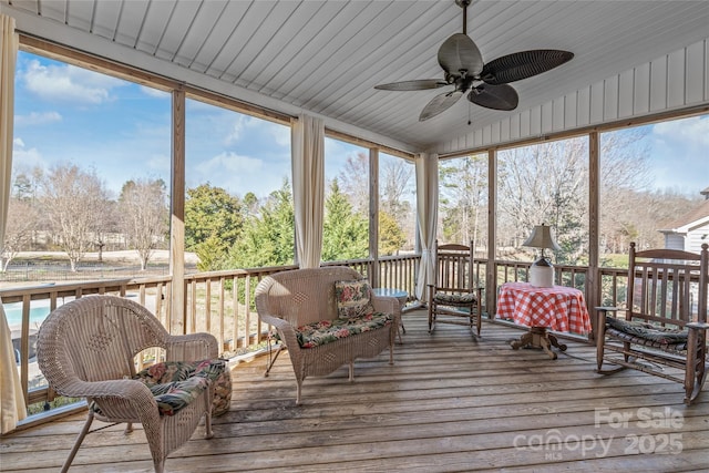 sunroom with a ceiling fan and vaulted ceiling