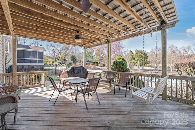 deck with outdoor dining area, a ceiling fan, and grilling area