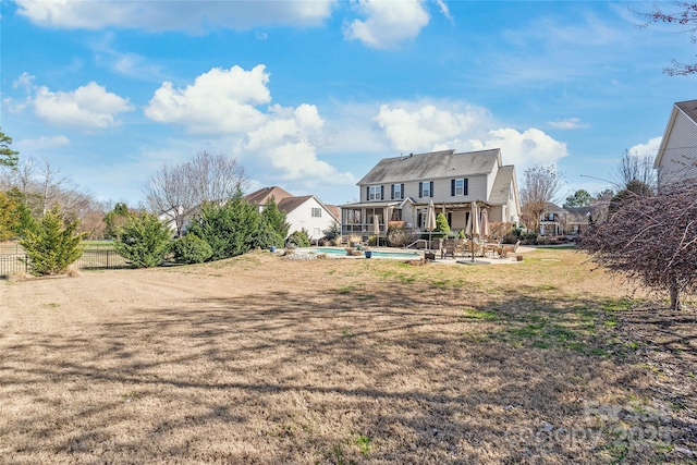 rear view of house featuring a fenced in pool, fence, a lawn, and a patio area