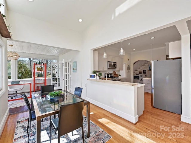 dining area with recessed lighting, light wood-type flooring, stairs, and baseboards