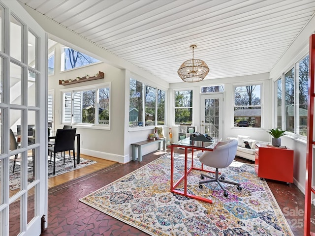 sunroom / solarium featuring an inviting chandelier