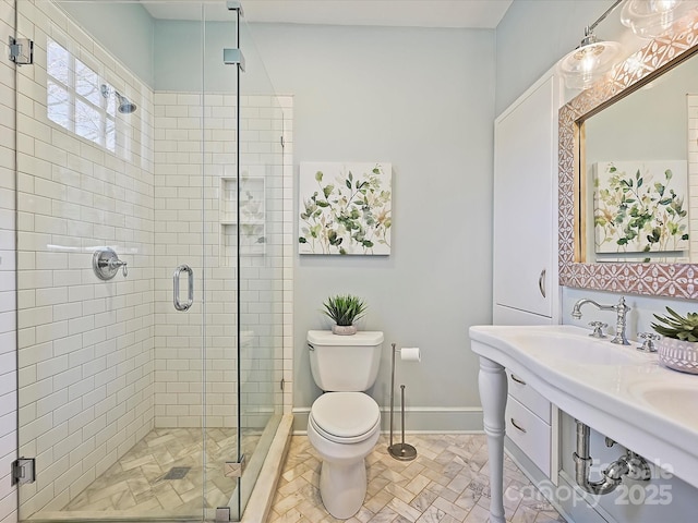 bathroom featuring baseboards, toilet, and a shower stall