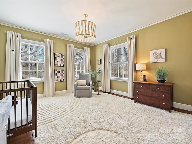 bedroom featuring visible vents, baseboards, ornamental molding, a notable chandelier, and a nursery area