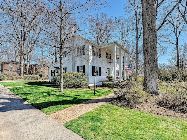 view of side of home with a lawn and a chimney