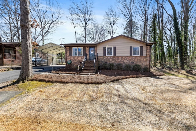 ranch-style house with crawl space, driveway, brick siding, and a carport