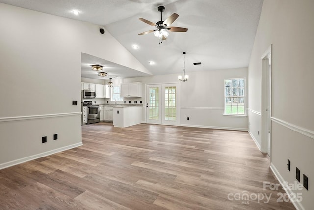 unfurnished living room featuring visible vents, high vaulted ceiling, light wood-type flooring, and baseboards