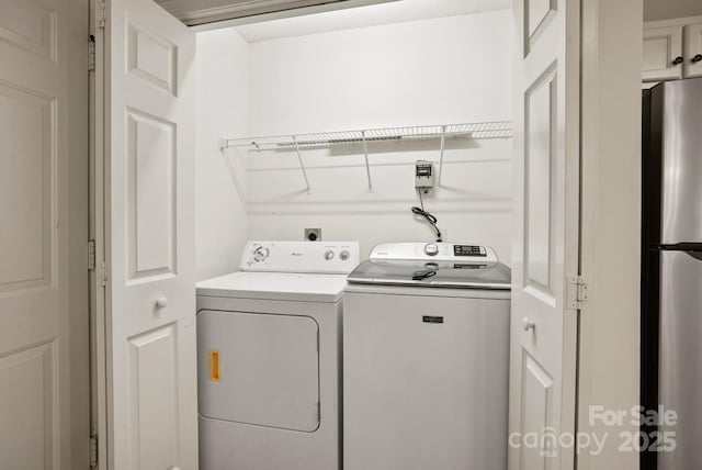 washroom with washing machine and clothes dryer and laundry area