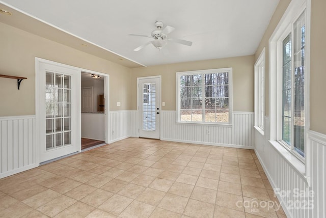 unfurnished sunroom featuring a ceiling fan