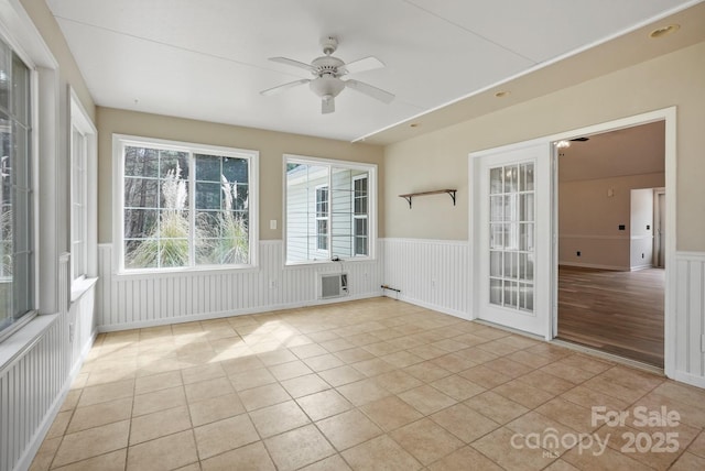 unfurnished sunroom featuring a ceiling fan