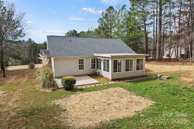 back of house with a yard, a patio, a sunroom, and a shingled roof