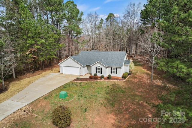 view of front facade with a front lawn, concrete driveway, a garage, and roof with shingles