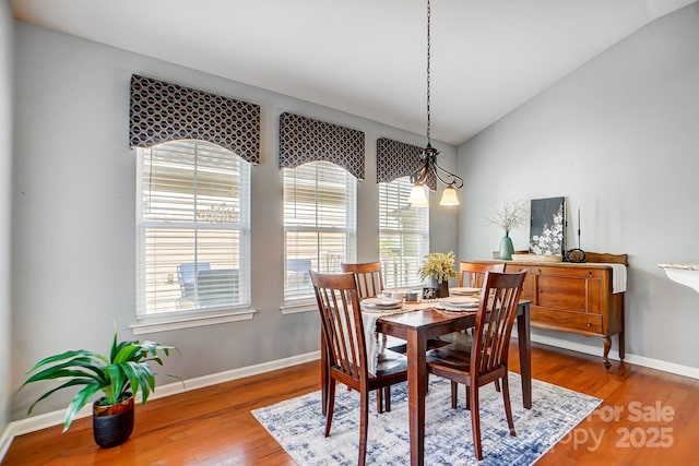 dining room with baseboards, lofted ceiling, and wood finished floors