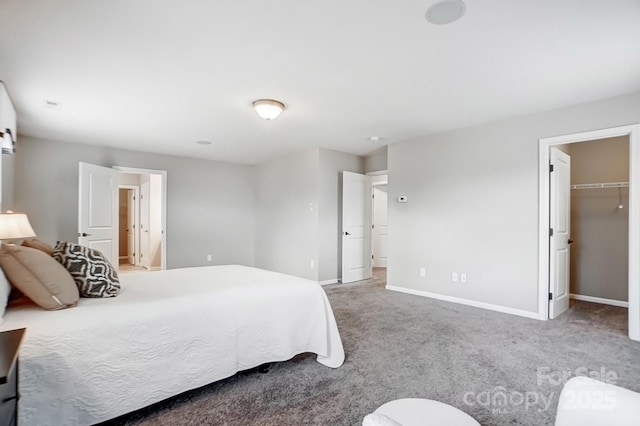 bedroom with baseboards, carpet floors, and a spacious closet