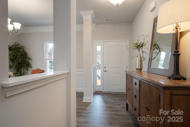 foyer featuring dark wood-style flooring, visible vents, ornate columns, and ornamental molding