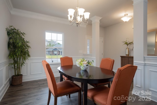 dining room featuring decorative columns, dark wood-style floors, ornamental molding, and a decorative wall