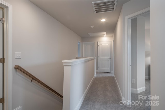 corridor featuring an upstairs landing, visible vents, carpet flooring, and baseboards