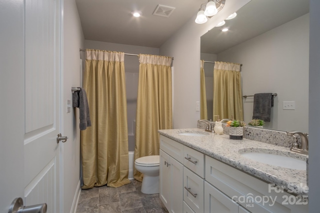 full bath featuring double vanity, visible vents, toilet, and a sink