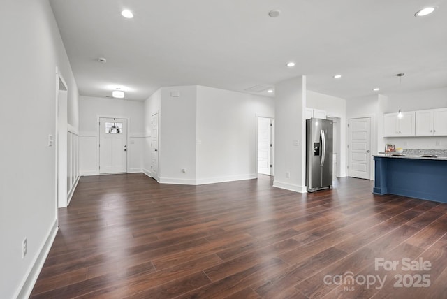 unfurnished living room featuring recessed lighting, baseboards, and dark wood-style floors