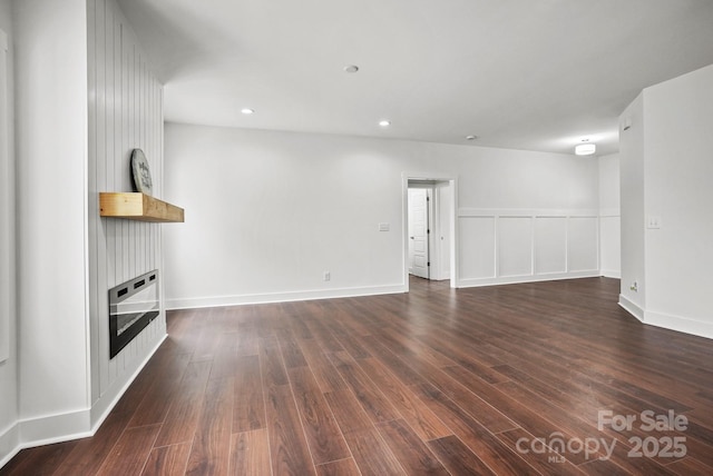 unfurnished living room featuring recessed lighting, baseboards, and dark wood-style flooring