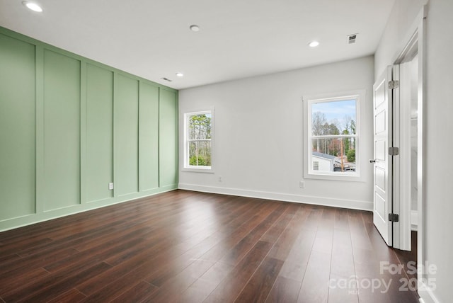 unfurnished room featuring recessed lighting, visible vents, a healthy amount of sunlight, and dark wood finished floors