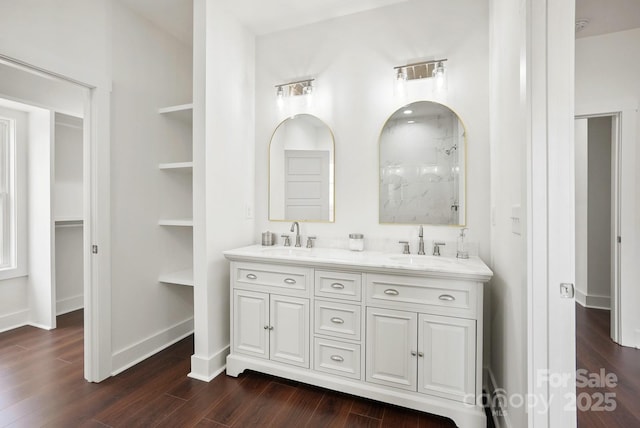 full bath with a sink, a shower, and wood finished floors