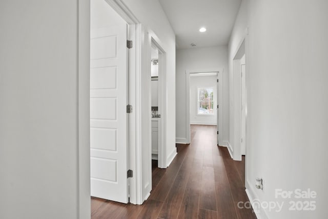 hall featuring recessed lighting, dark wood-style floors, and baseboards