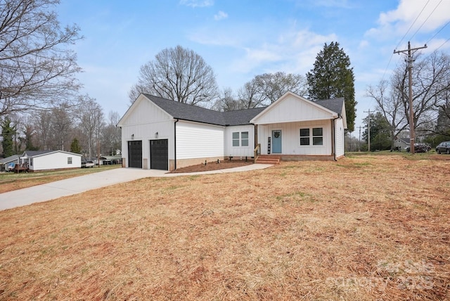 view of front of property with a front yard, a garage, driveway, and roof with shingles