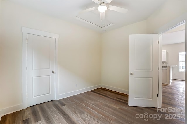 empty room with a ceiling fan, wood finished floors, and baseboards