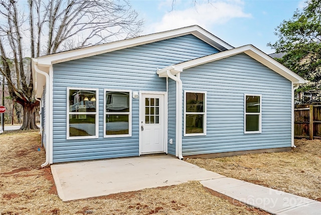 rear view of property featuring a patio and fence