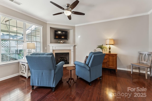 living area featuring visible vents, baseboards, a ceiling fan, and hardwood / wood-style flooring