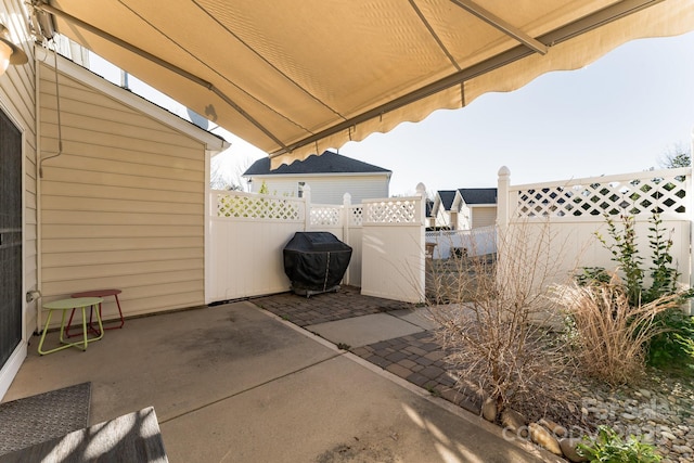 view of patio with grilling area and a fenced backyard