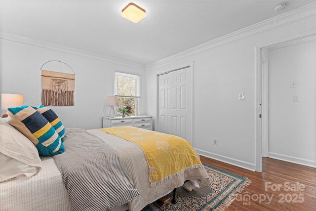 bedroom featuring baseboards, a closet, crown molding, and wood finished floors