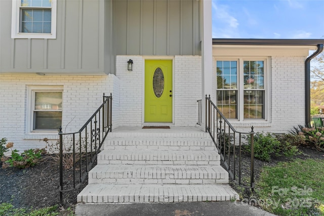 property entrance featuring brick siding and board and batten siding