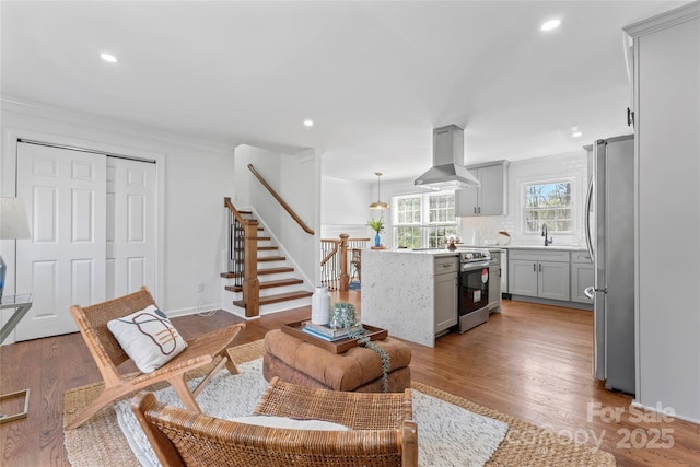 living room featuring recessed lighting, crown molding, stairway, and wood finished floors