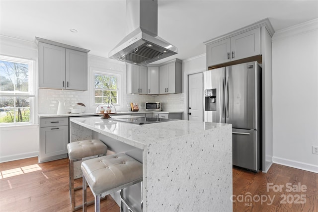 kitchen featuring gray cabinets, stainless steel fridge, and range hood