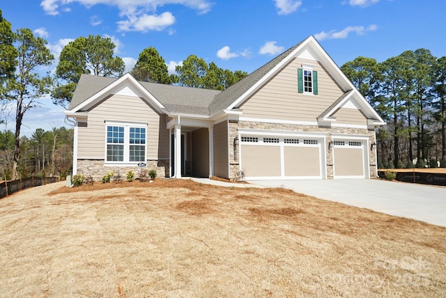 craftsman inspired home featuring stone siding, an attached garage, concrete driveway, and a shingled roof