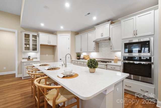 kitchen featuring white cabinetry, stainless steel appliances, and light countertops